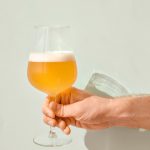 白い壁にグラスに入ったビールが注がれている