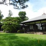「旧大隈重信別邸・旧古河別邸」の外観。青い芝生の庭と日本式の木造建築の邸宅。