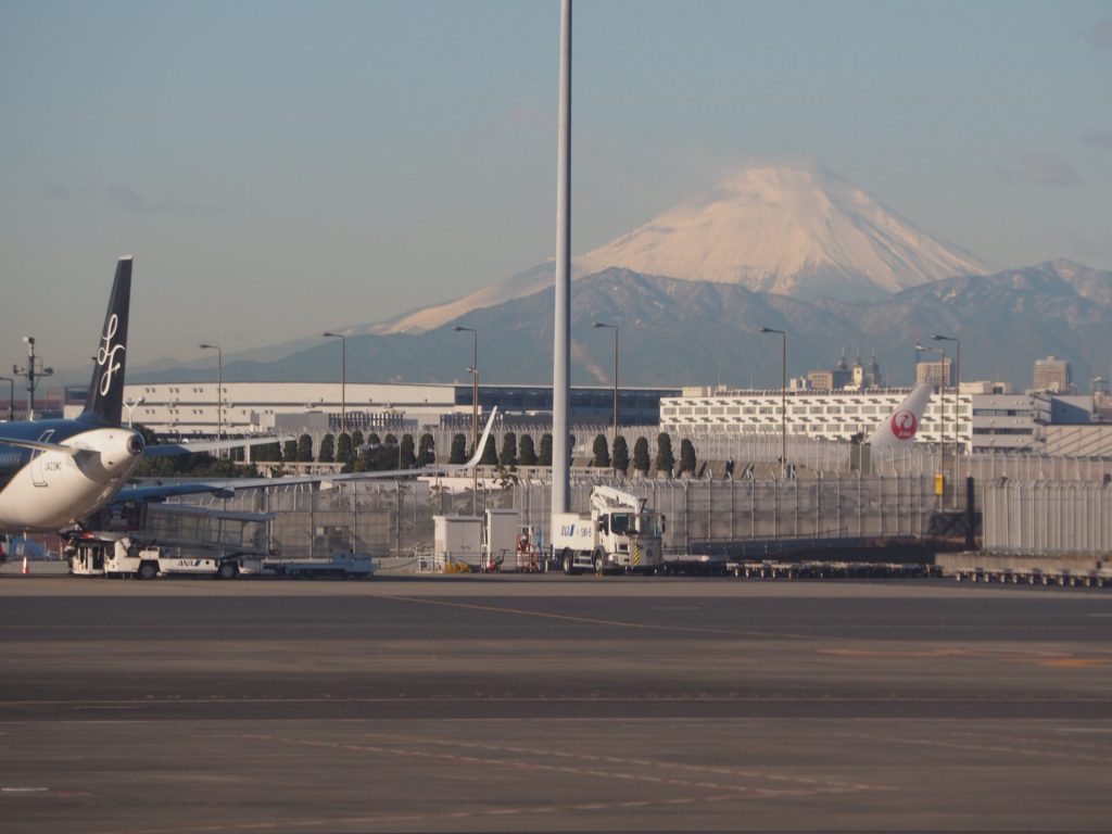 羽田空港の滑走路の風景写真。飛行機と遠くには富士山が写っています。