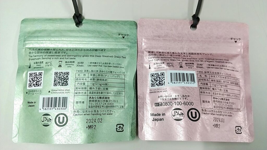 「日本茶きみくら」の商品「Art Print Package (Teabag) Collection」（全６種）の中の2種類。緑系のパッケージとピンク系のパッケージの裏面を並べて撮影した写真。
