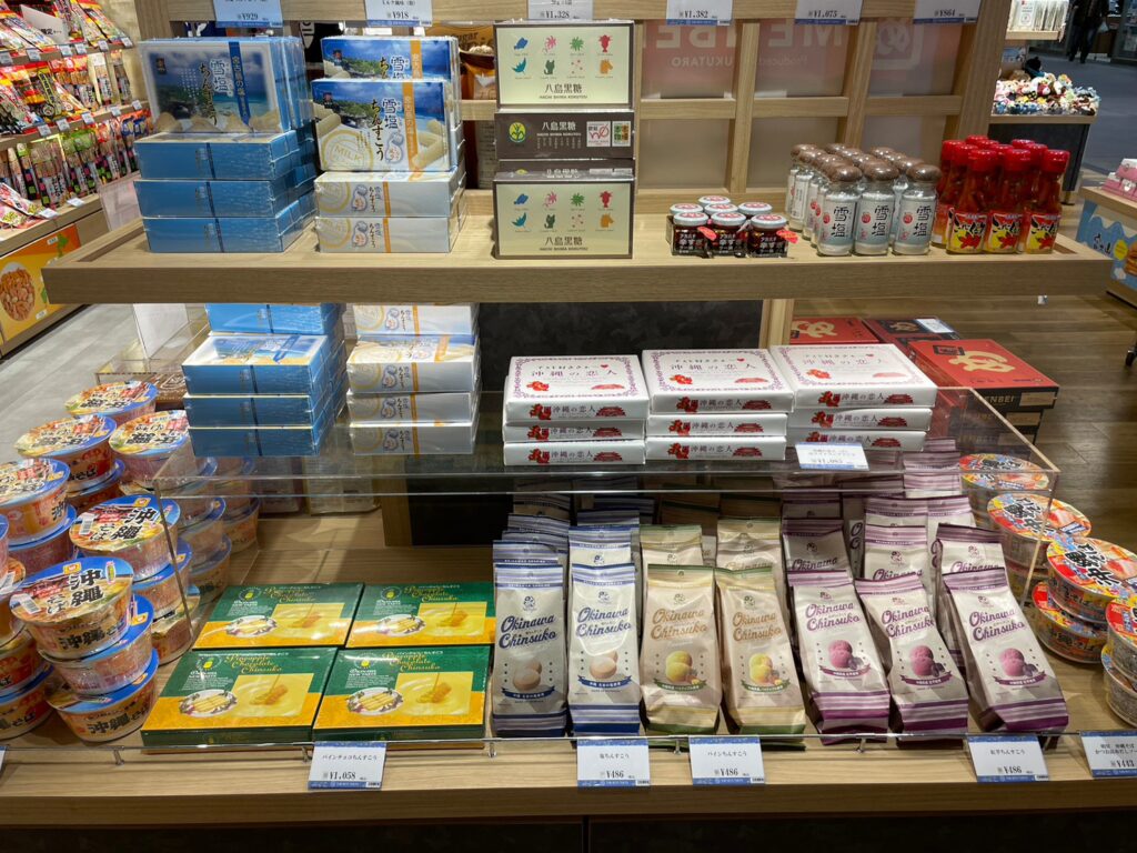 羽田エアポートガーデン内のお菓子のギフトショップ「TOBI•BITO SWEETS」の沖縄県コーナー。たくさんの商品が陳列しています。