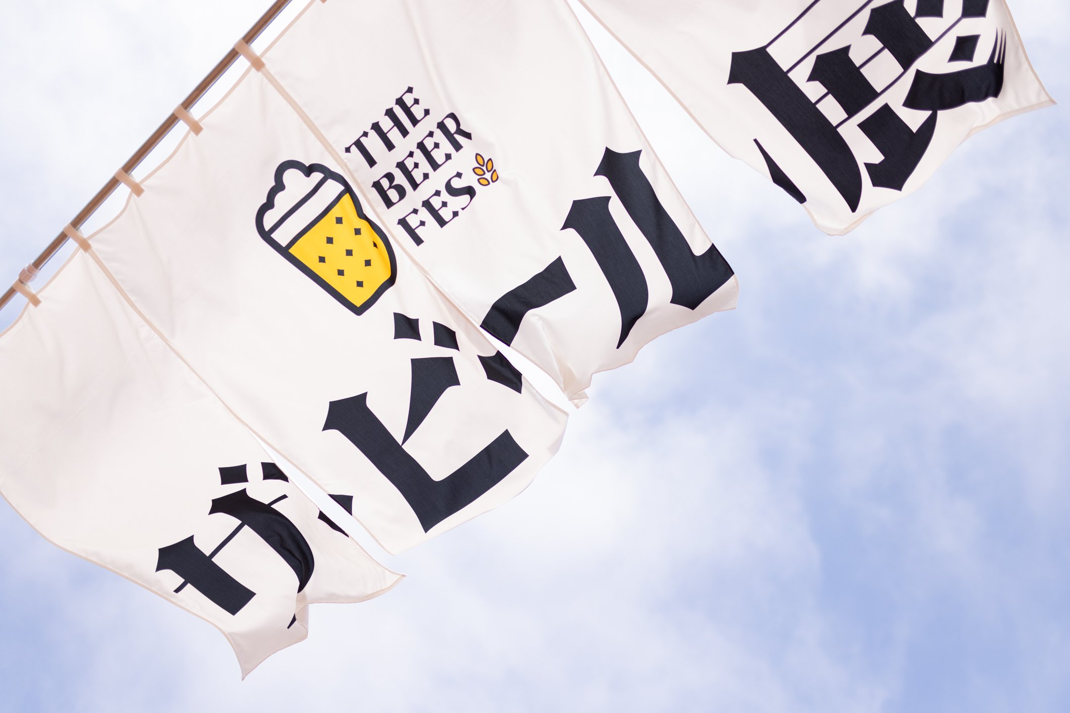 新潟県柏崎市で開催される「ザ・ビール展 2025」のイベント旗と青空